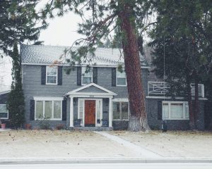 A snowy house with a paver walkway that needs to be maintained